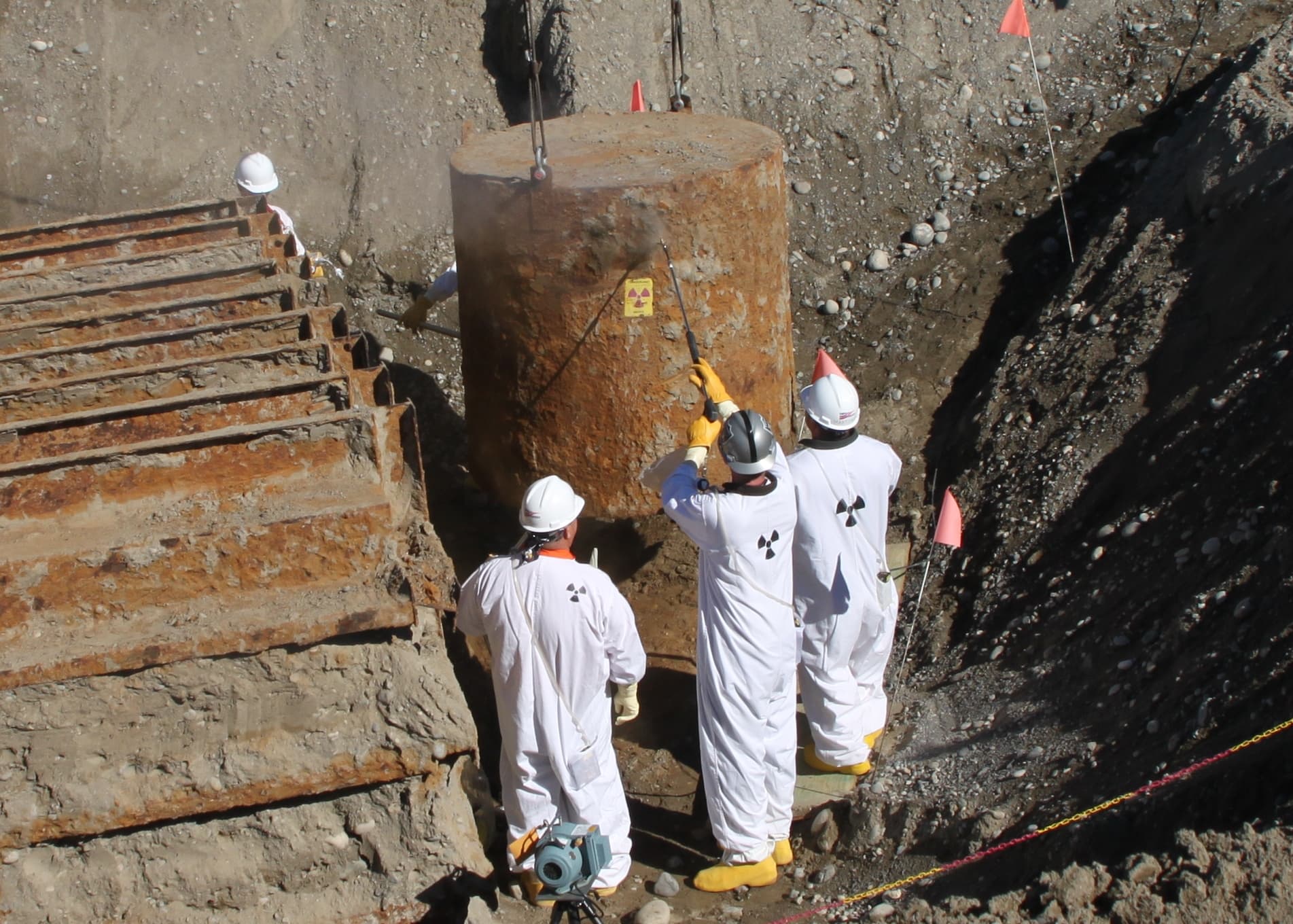 Workers remove a waste container from Trench 8 at the Hanford Site in Washington state in 2010