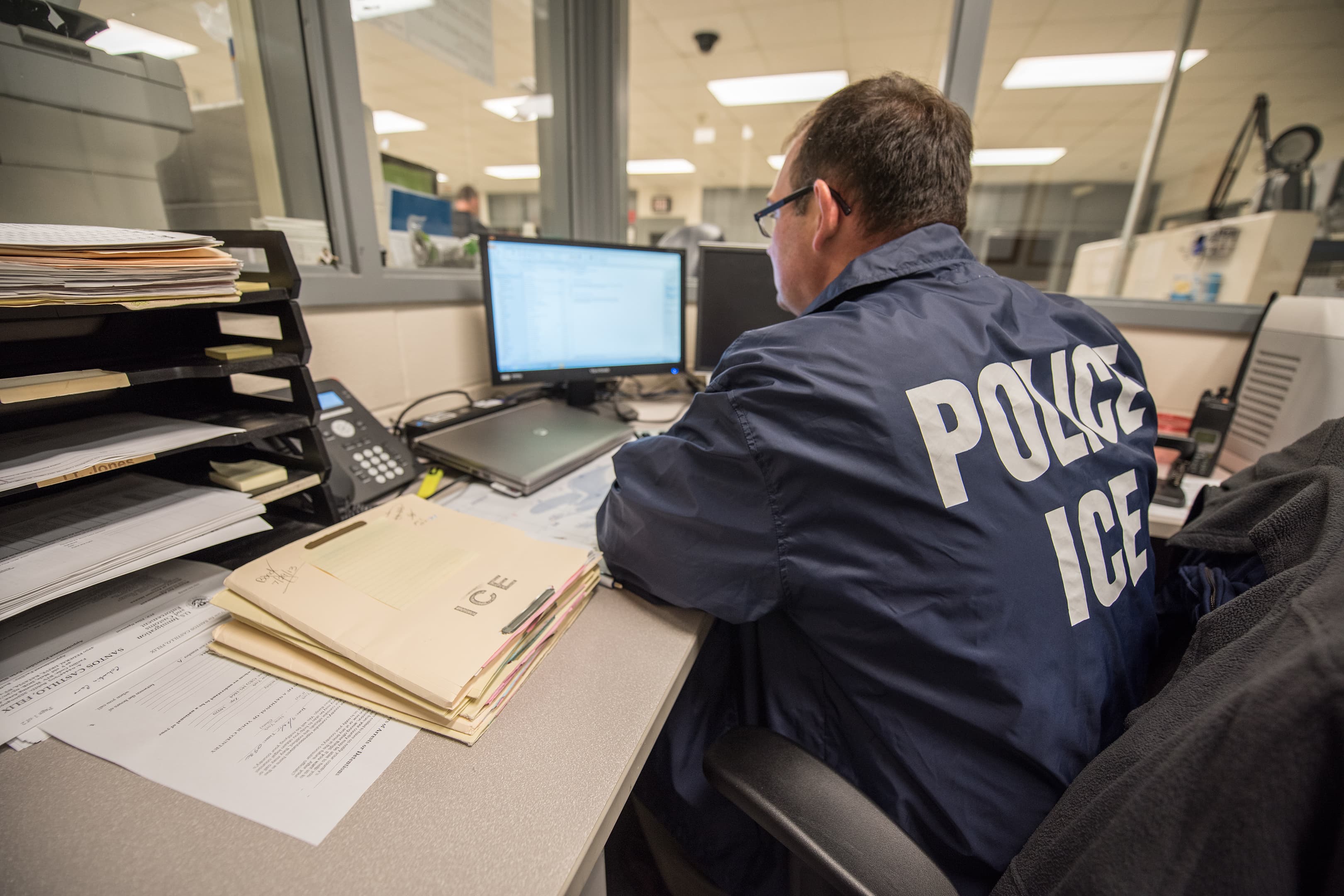 An ICE officer monitors a detention facility (archival)